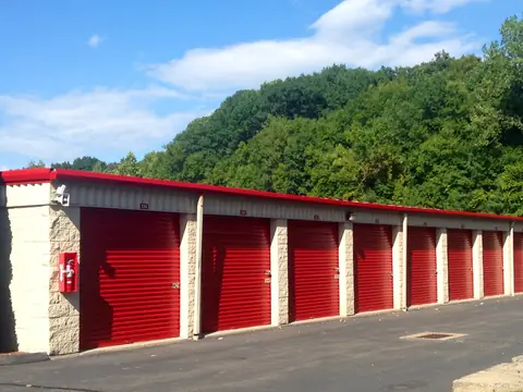 A long row of red roll-up doors at a self storage facility
